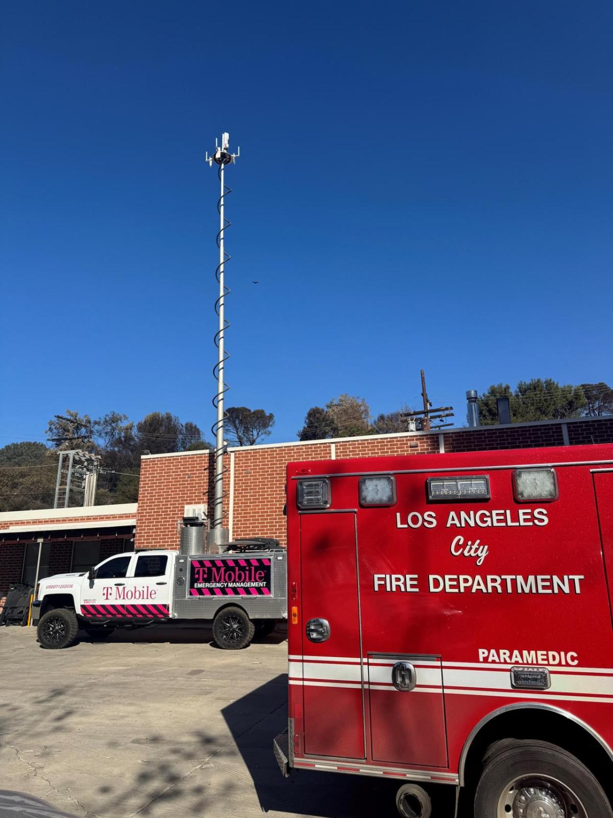 Emergency and T-Mobile vehicles in front of a building