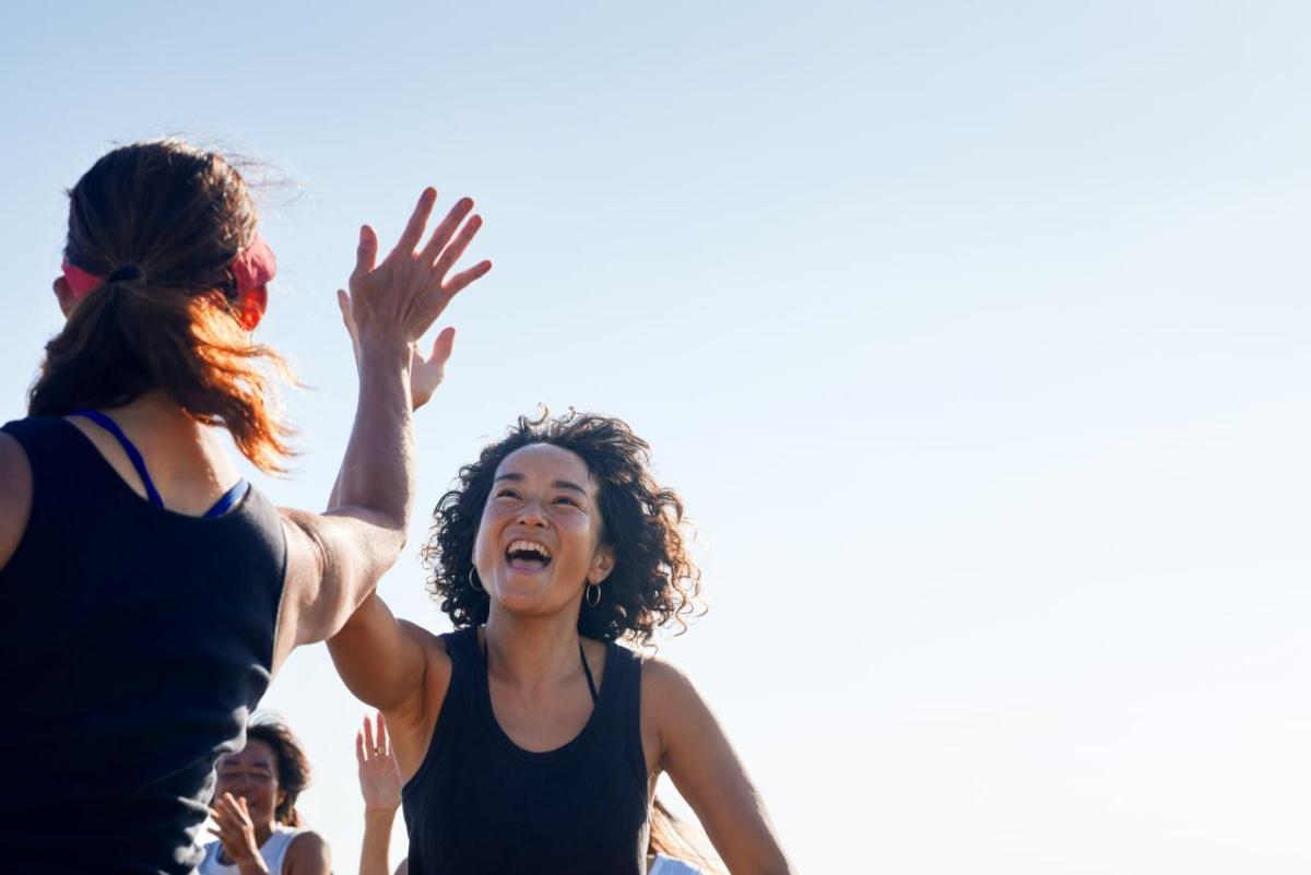 Two people high-fiving outside