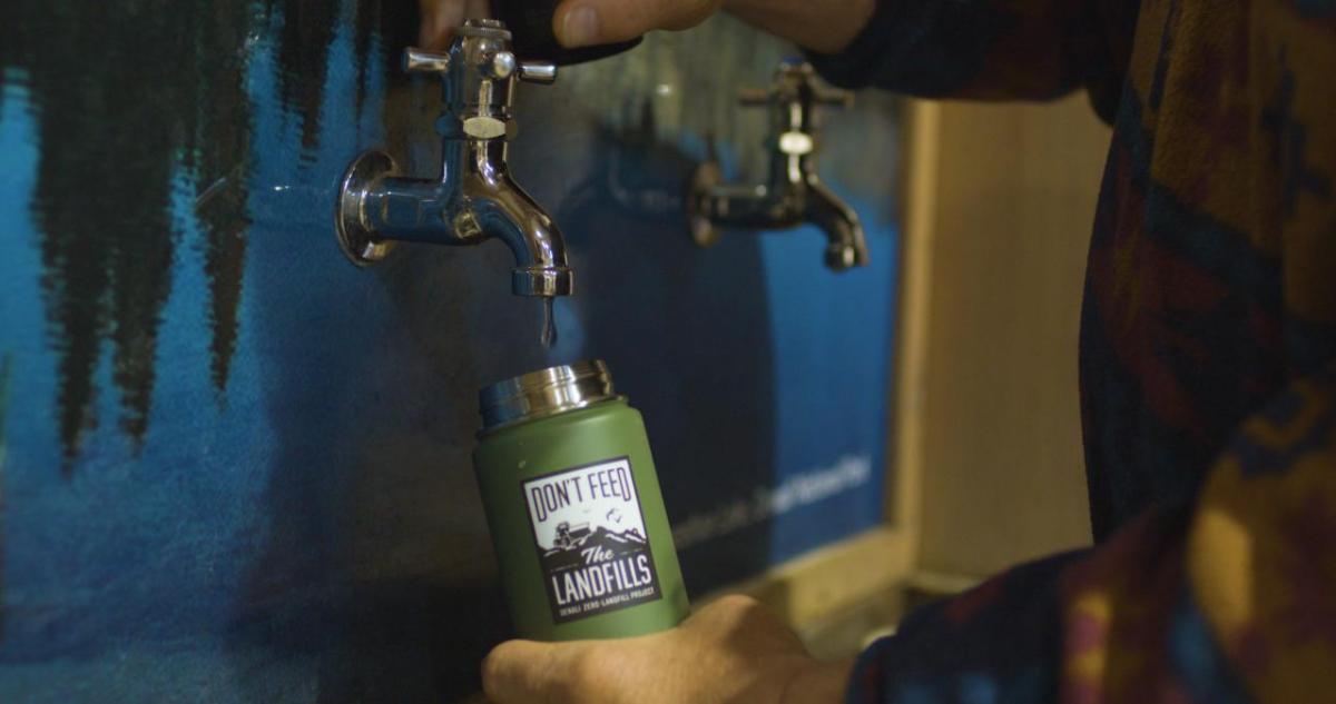 A person refilling a water bottle 