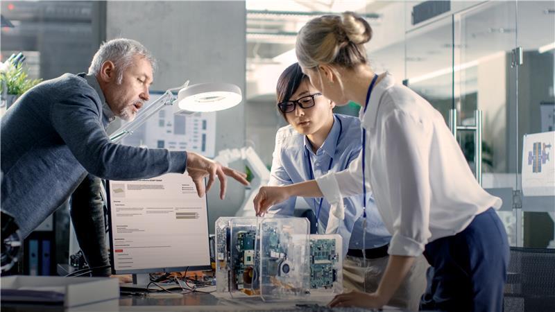 Group of three technicians looking at computer hardware.