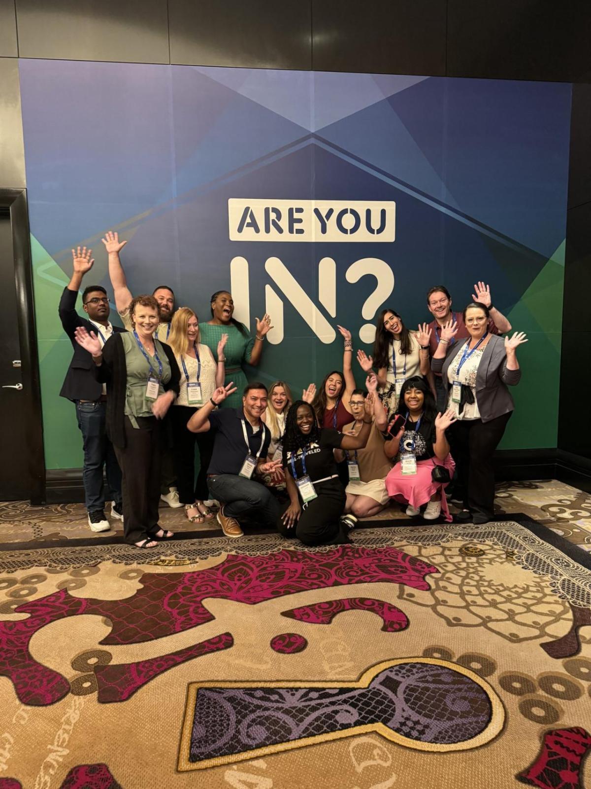 People posing in front of a Disability:IN Conference back drop 