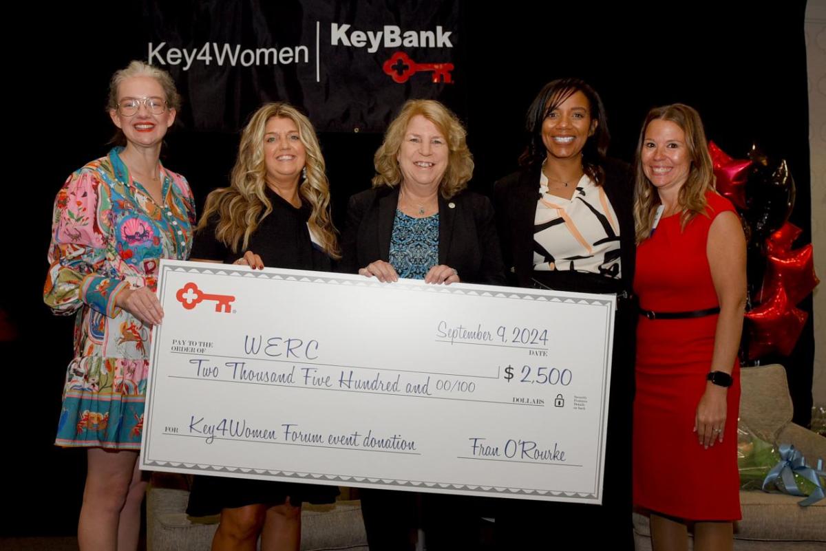 Five people smiling and holding an oversized check from KeyBank