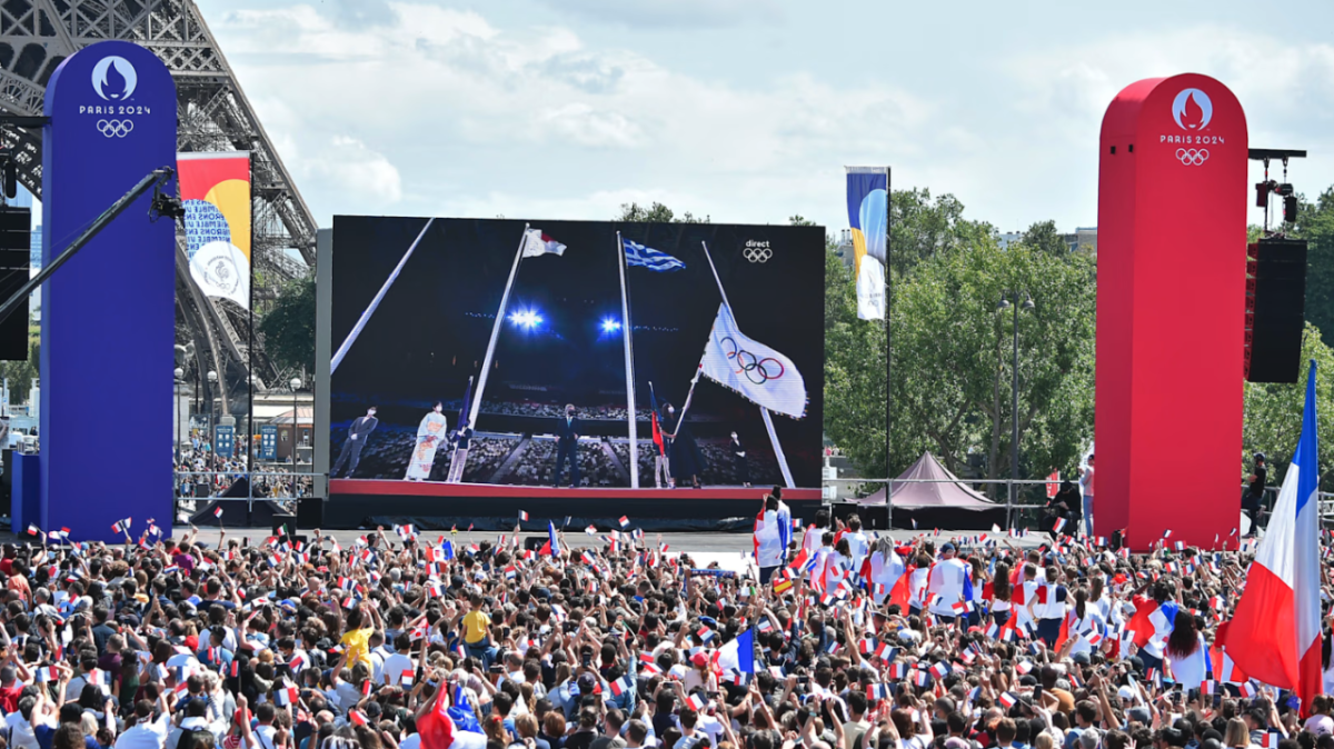 A giant screen being watched by a large crowd