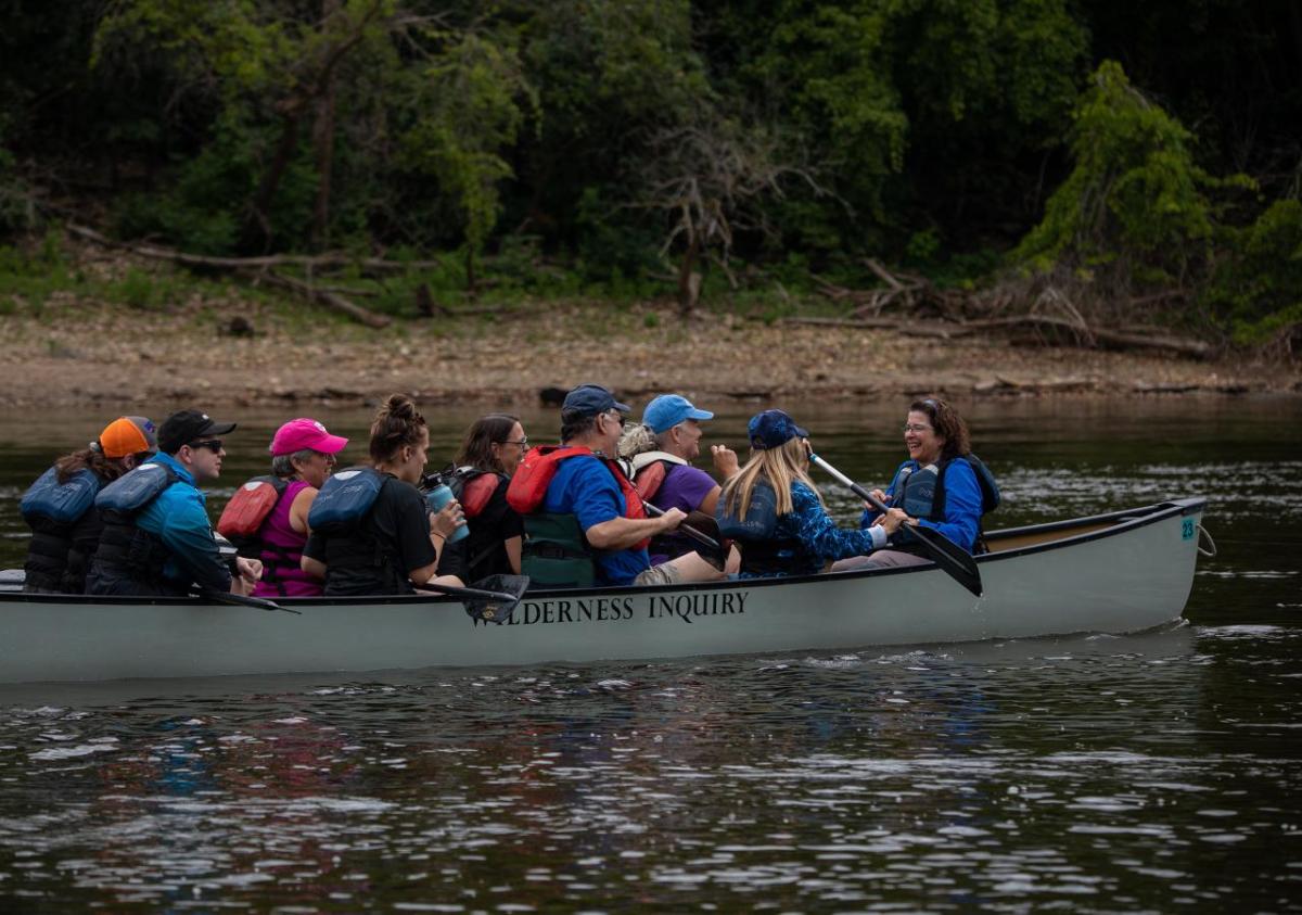 Many people in a canoe going downriver