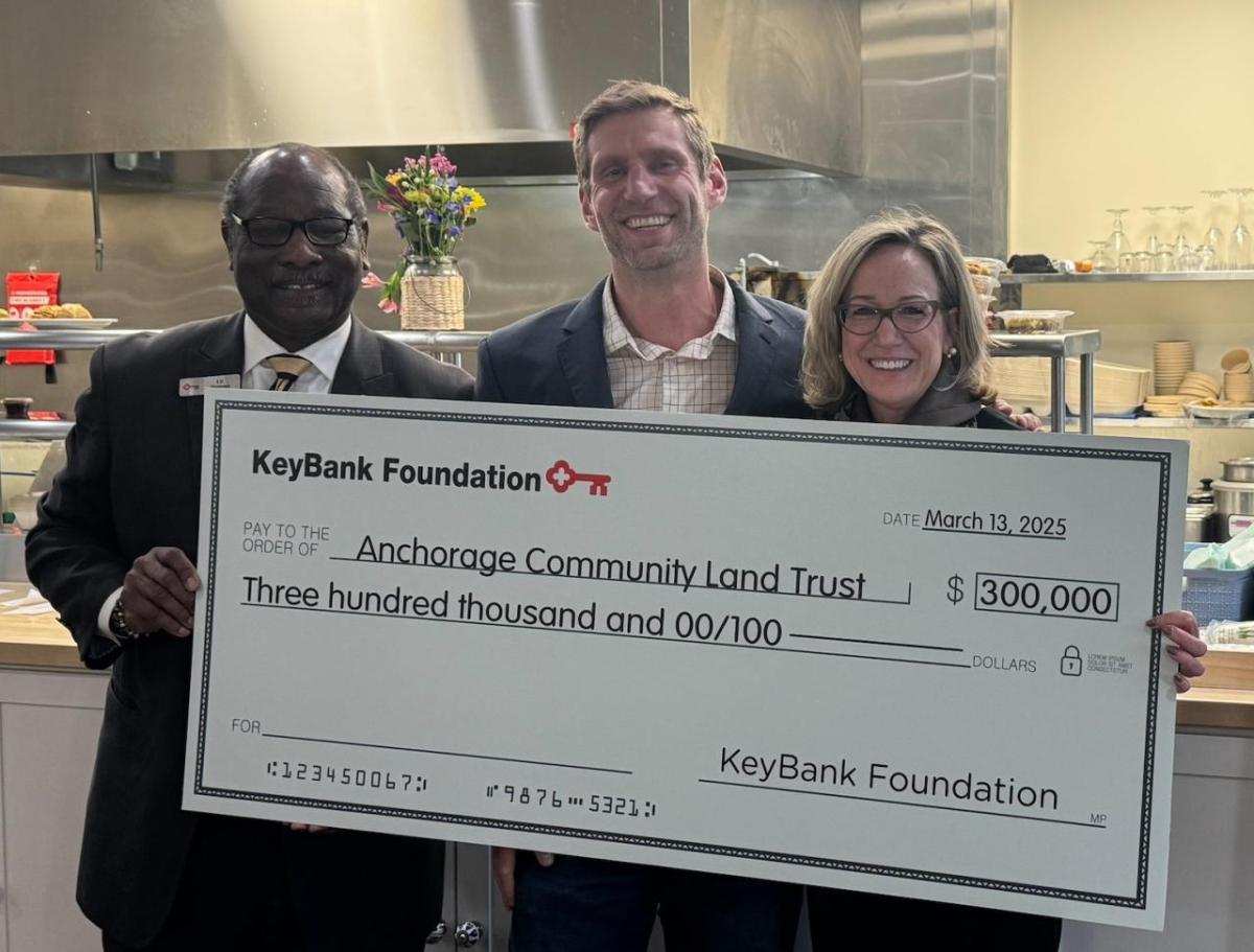 3 people hold a KeyBank Foundation check for $300,000.