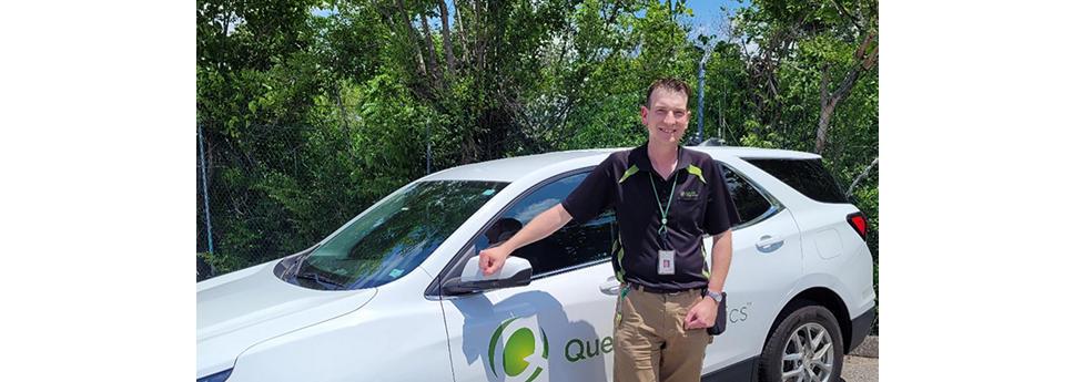 Adam Slough standing by a Quest car outside