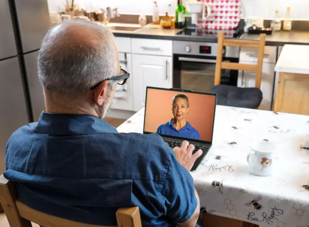 A person sat at a table using a laptop