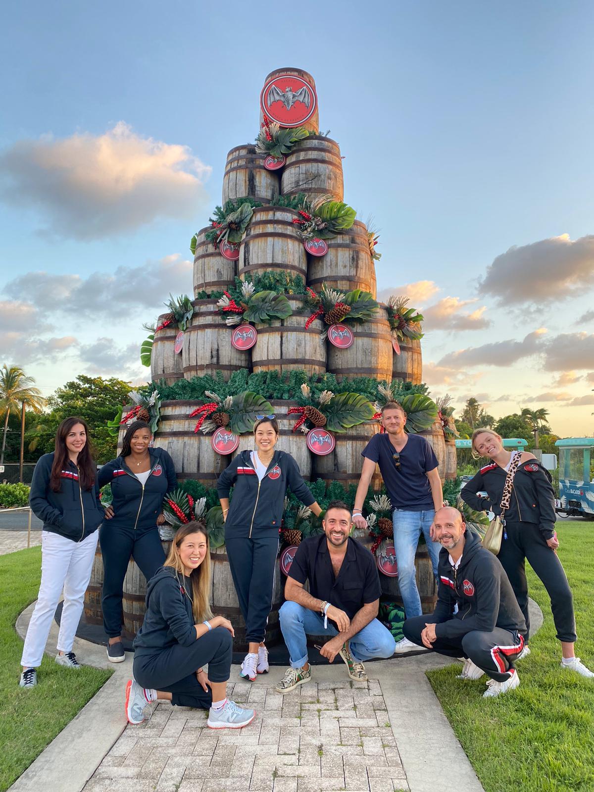 Bacardi team members grouped in front of a pyramid of barrels