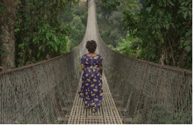 woman walking alone across a long bridge