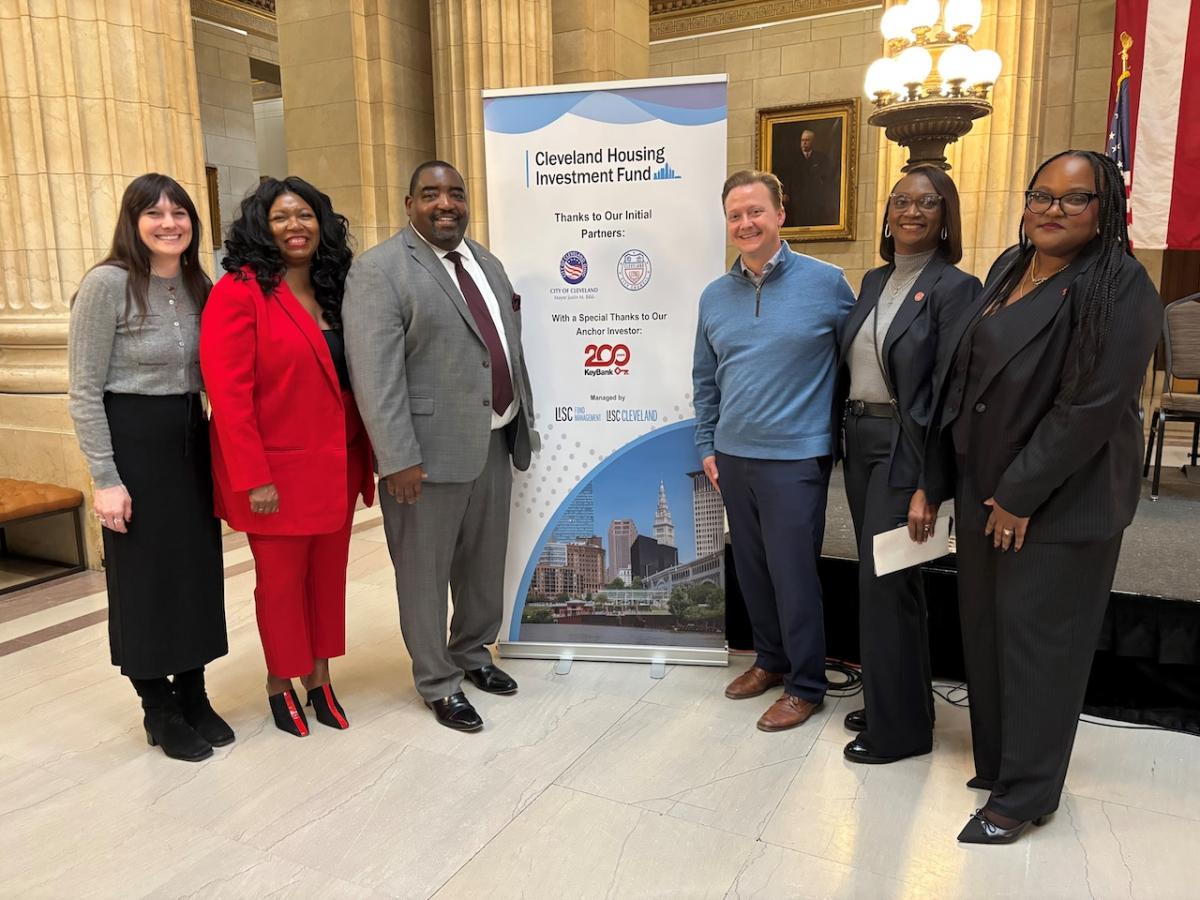 Representatives from the City of Cleveland and KeyBank shown in front of the Cleveland Housing banner.