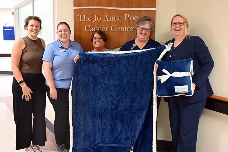 A group of people at the Jo Anne Poe Cancer Center holding a blanket