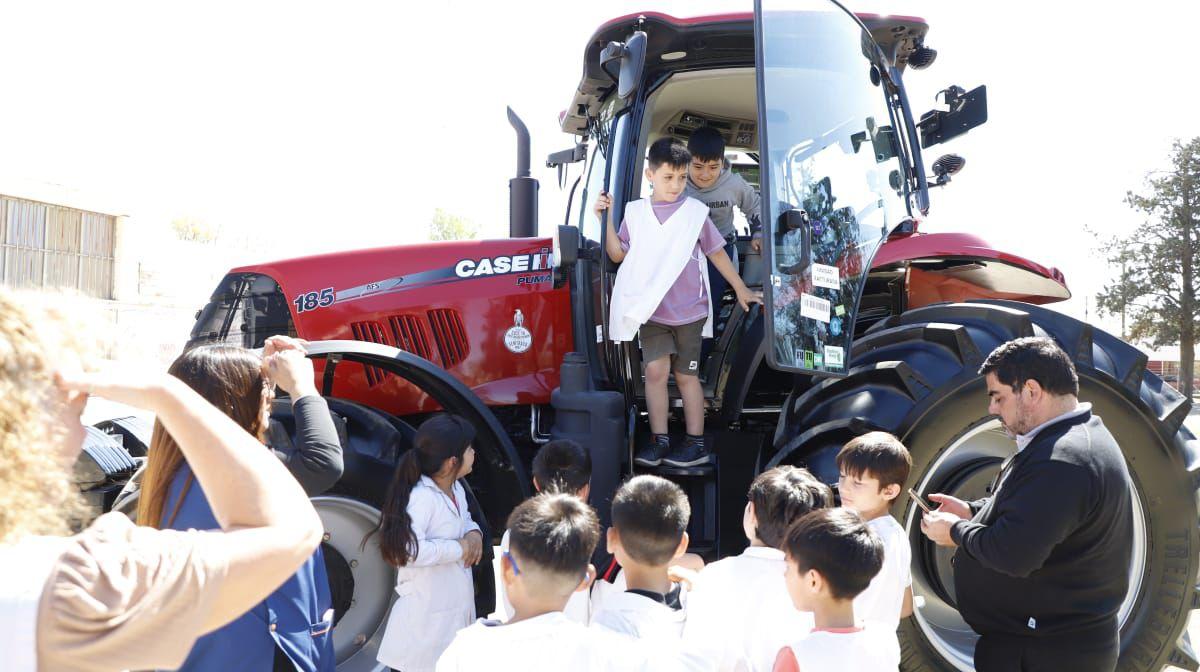 Children looking at and climbing into red tractor