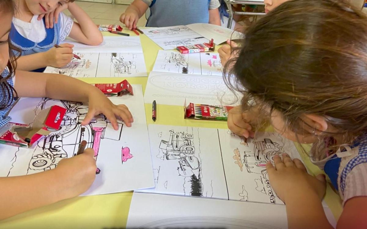 Children coloring in pictures of tractors