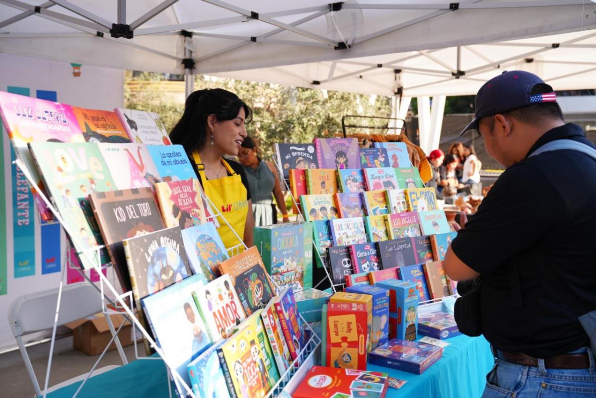 An attendee browses the book collection at Lil' Libros pop-up shop.