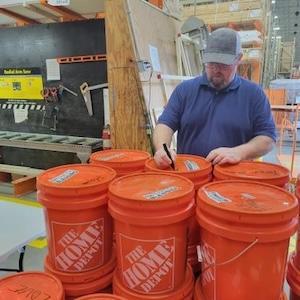 The Home Depot volunteer preparing Homer buckets for disaster relief.
