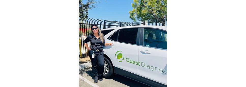 Esmeralda Bonilla standing next to a Quest vehicle