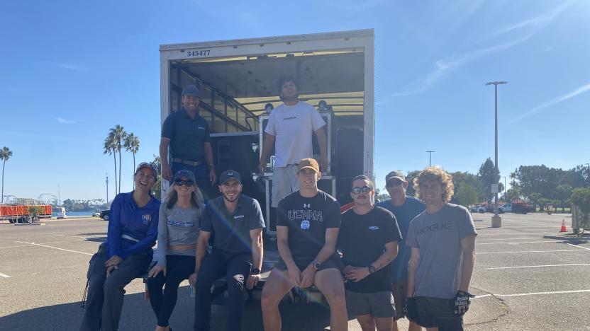 A group of people sitting and standing on the back of an open lorry 