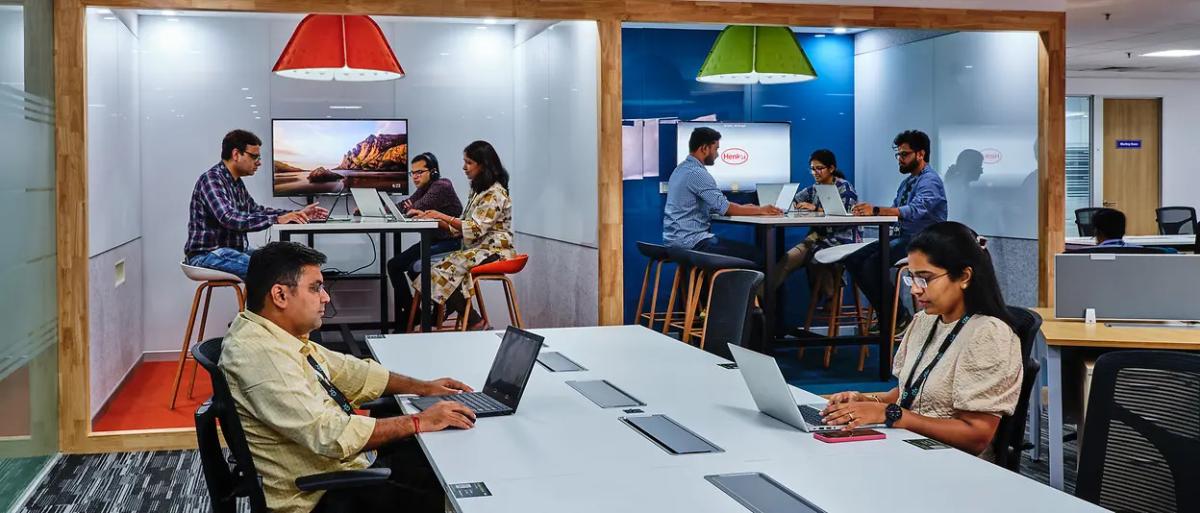 People at different tables, all working on laptops.