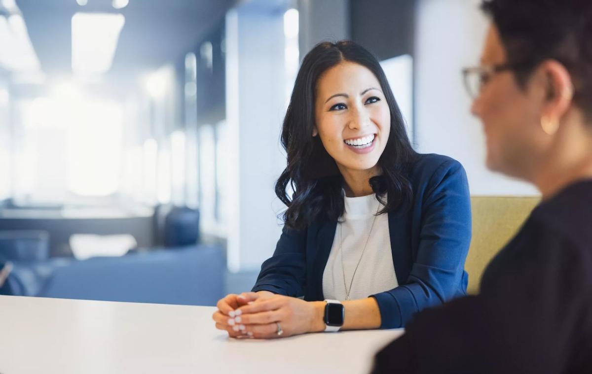 Two employees seated at a table chatting.