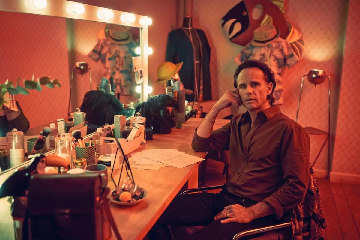 Walter Goggins seated at a dressing table.