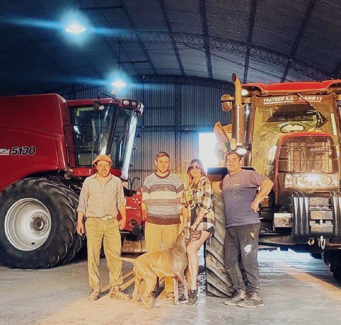 Group photo with dog in front of tractors