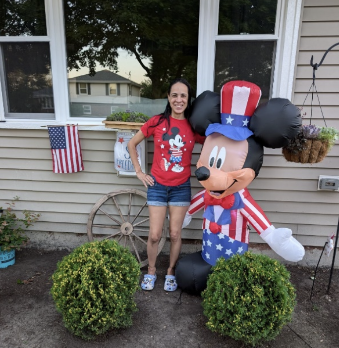 Valerie, shown with Mickey Mouse, in front of her refurbished home.