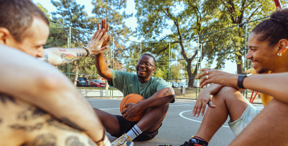 Group of men giving a high-five on a basketball court.