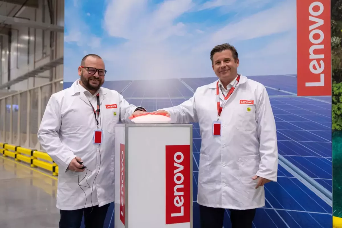 Two people stood in front of a Lenovo banner 