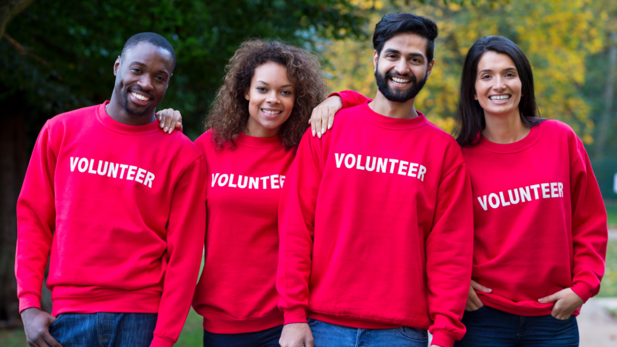 four volunteers with red shirts smiling 