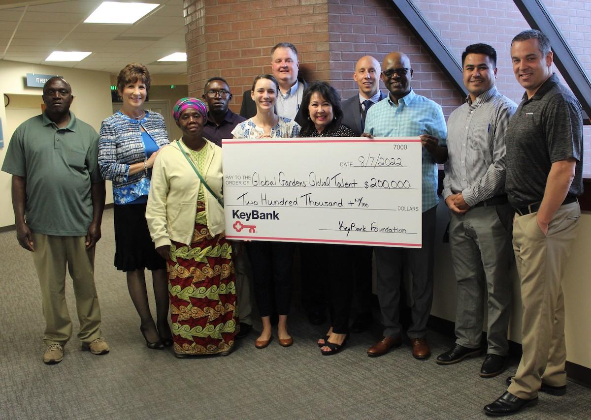 Jannus and KeyBank employees hold a donation check.