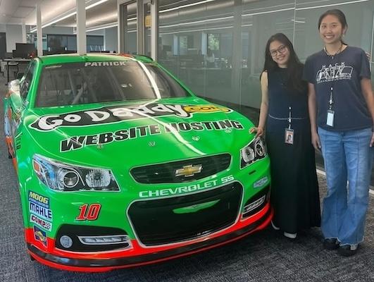 Kim shown in front of a bright green race car.