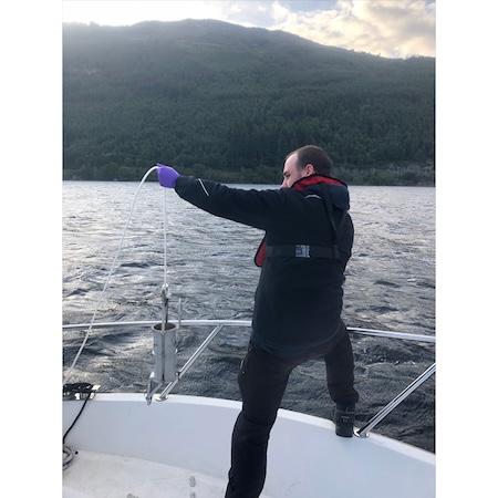 Gert-Jan Jeunen prepares to lower a sampling container into the water. | Photo by Neil Gemmell