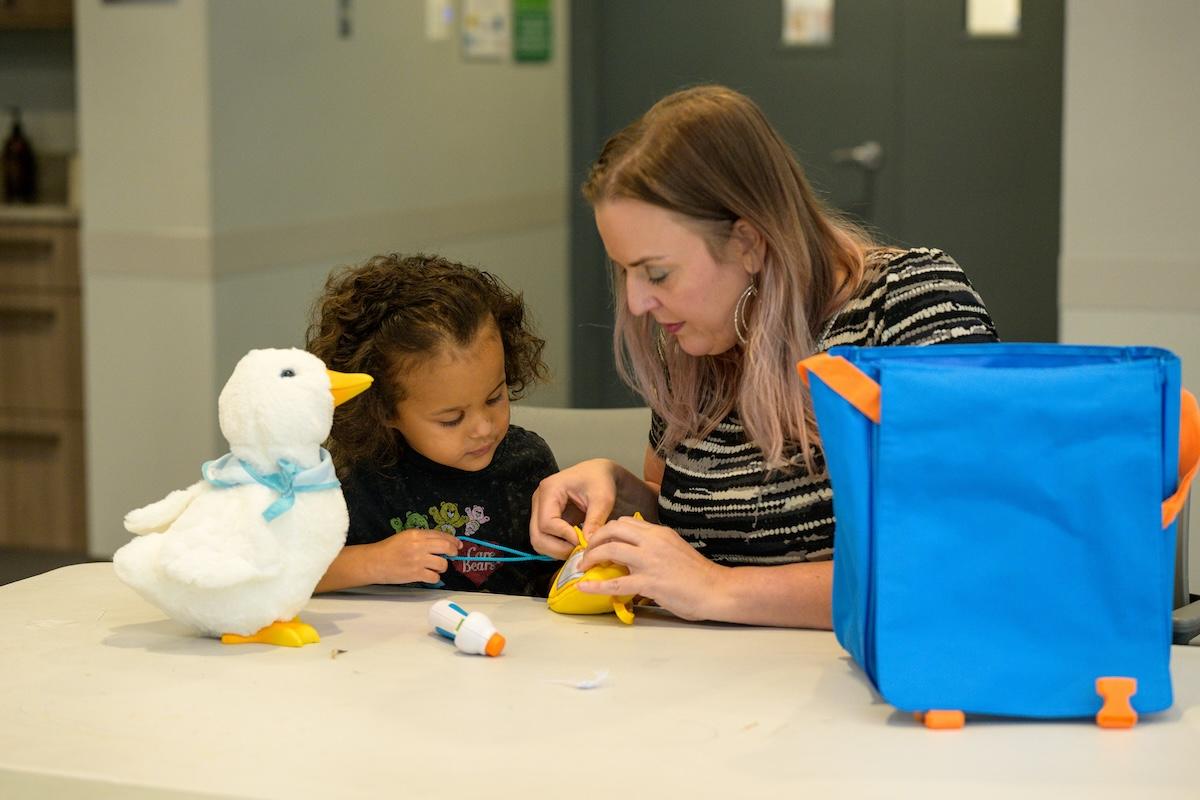 adult with child and stuffed toy duck