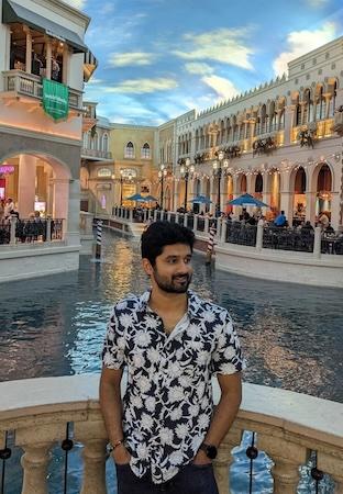 Manoj shown at a resort in Las Vegas with Venetian canals behind him.