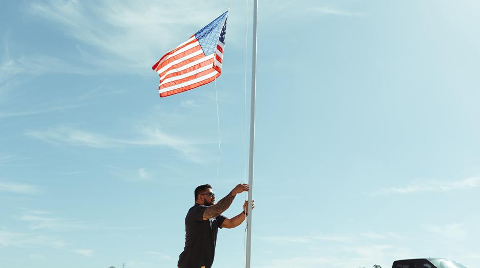 Maverick raising a flag in front of his new home.