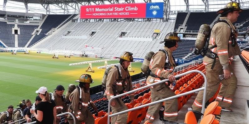 firefighters climbing stairs in a stadium 