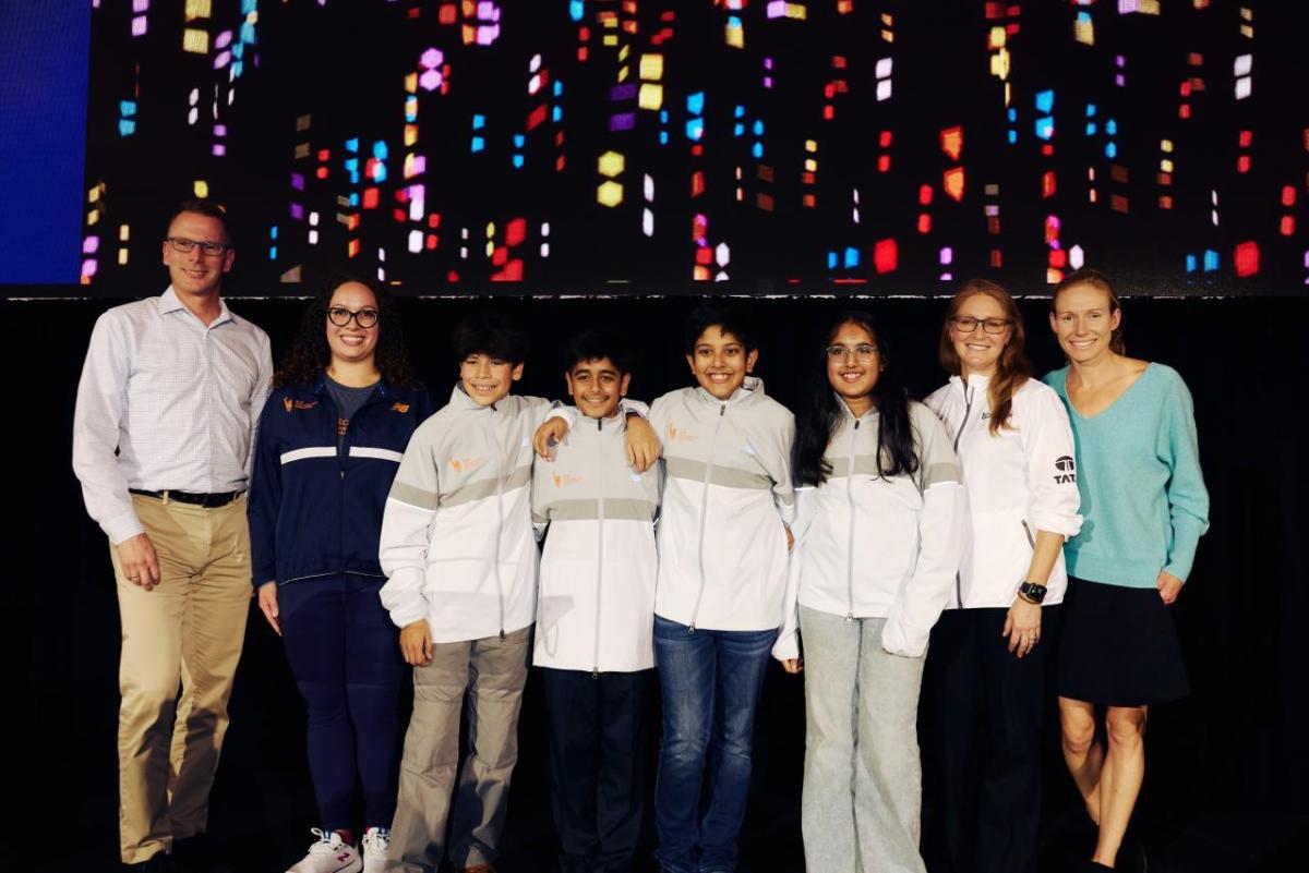 A group of students stood together for a photo with adults either side 