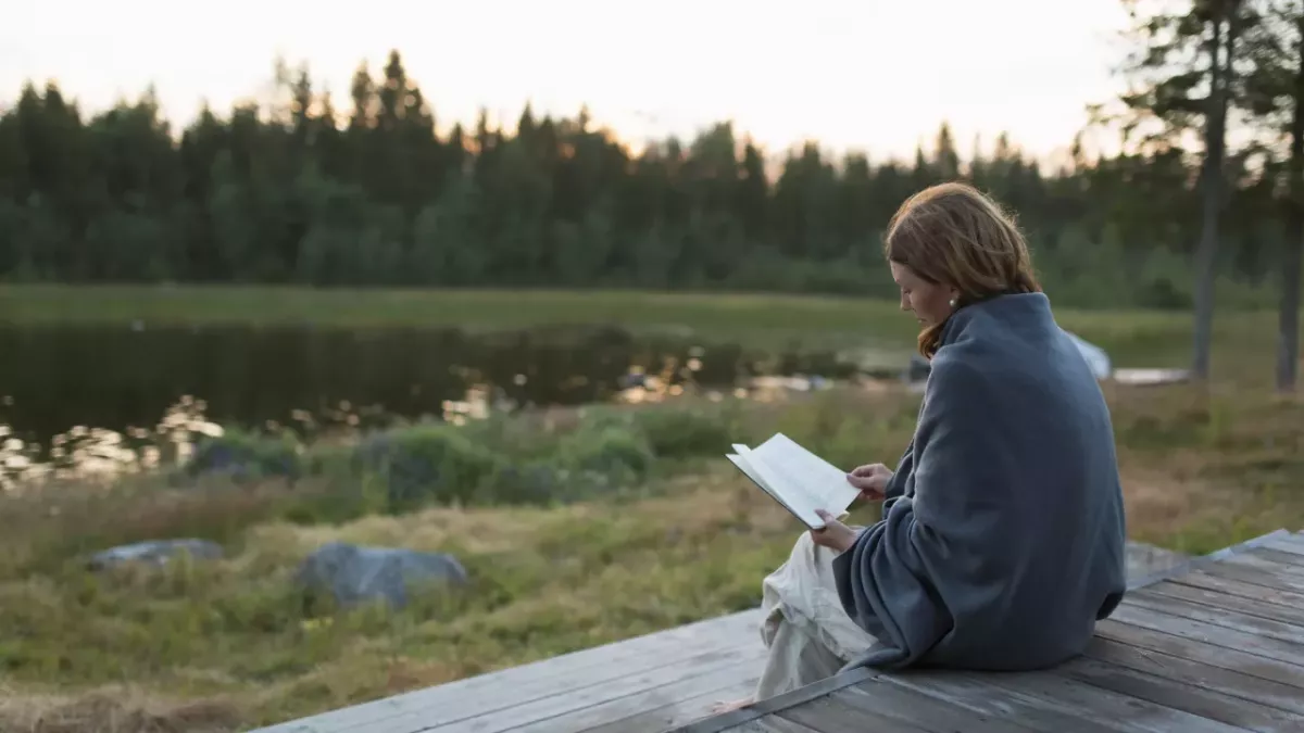 person sitting outside reading a book 