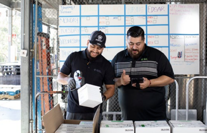 Two workers scanning products out of boxes