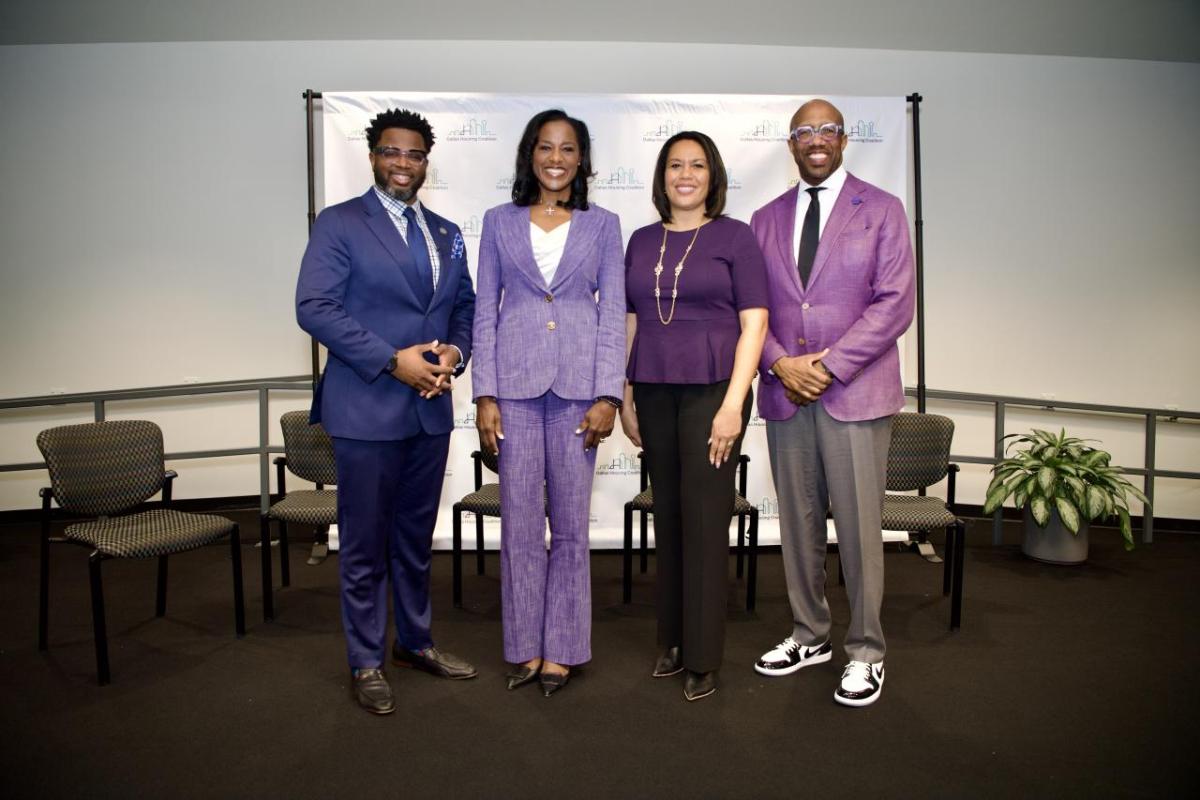 Four people standing in a conference room