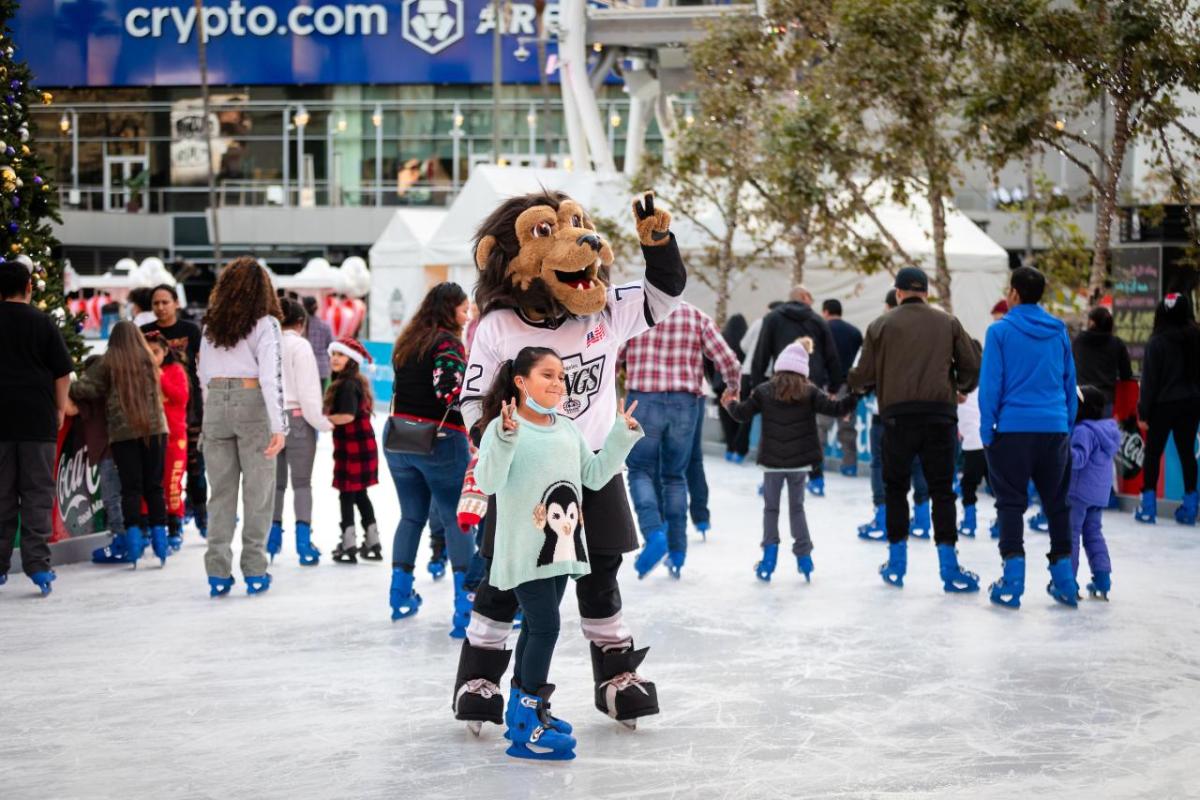 A child ice skates with LA Kings mascot Bailey at AEG's Community Ice Skating Party at L.A. LIVE.