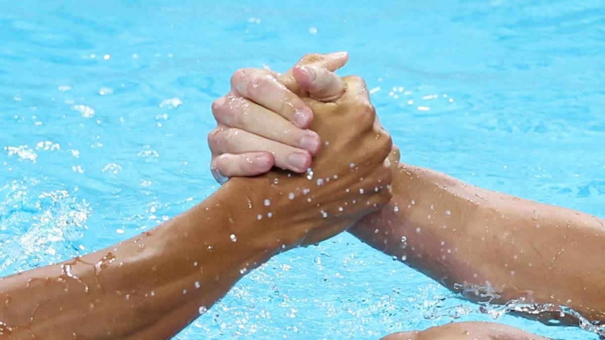 Two people shaking hands above water