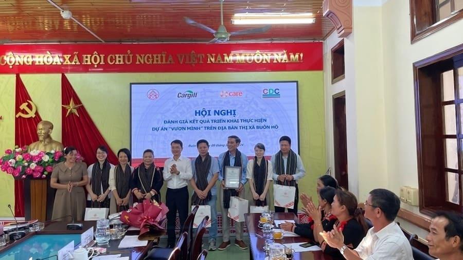 Meeting participants standing together at project evaluation meeting in Buon Ho District.