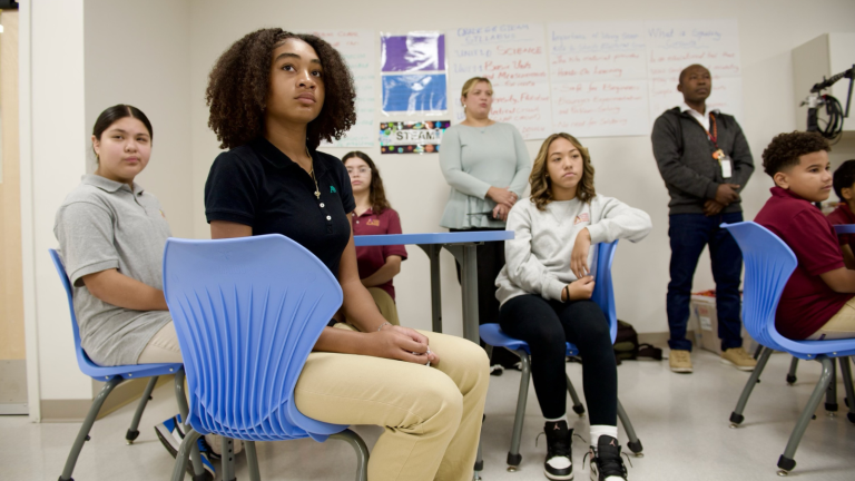 Students sat on blue chairs 