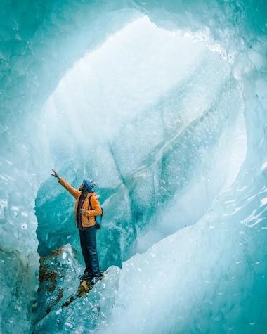 Thomas Allison photograph of an ice climber inside a glacier.