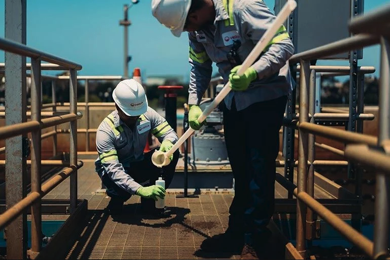 two workers testing water