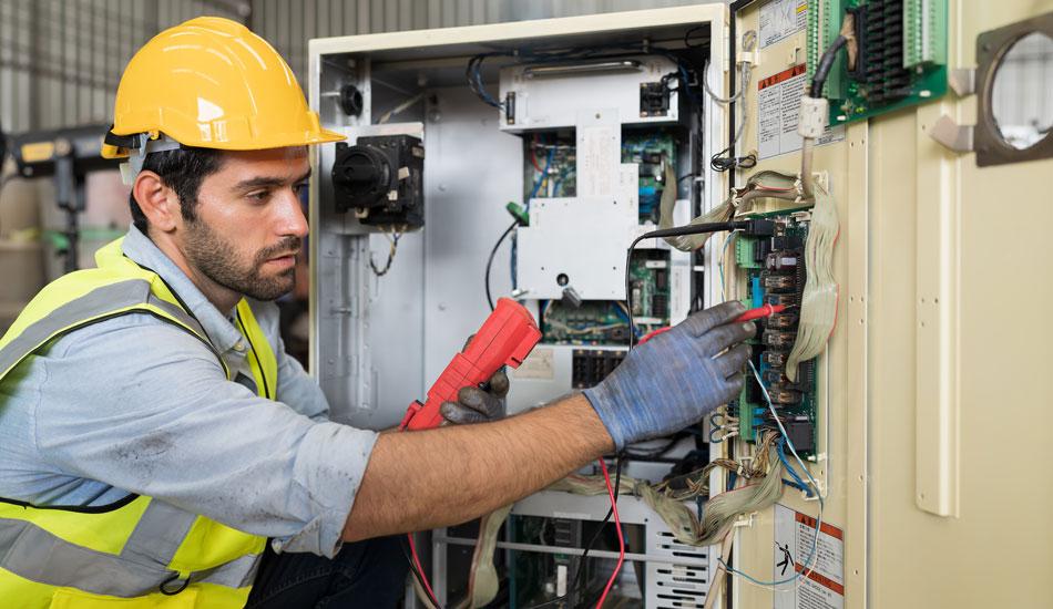 Electrical worker shown checking a circuit breaker.