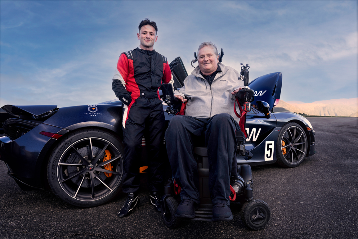 A person leaning against a car and a person in a wheelchair next to them 