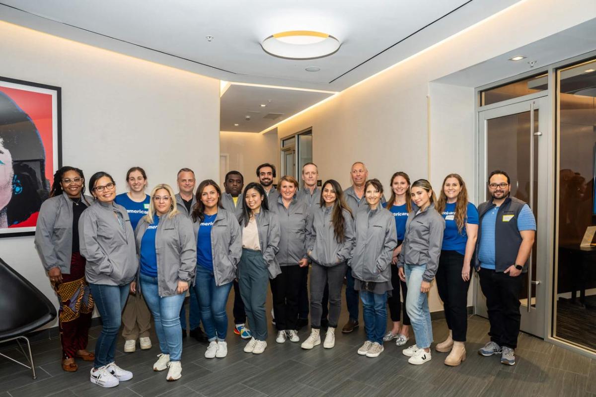 group of people posing for group picture with gray jackets on