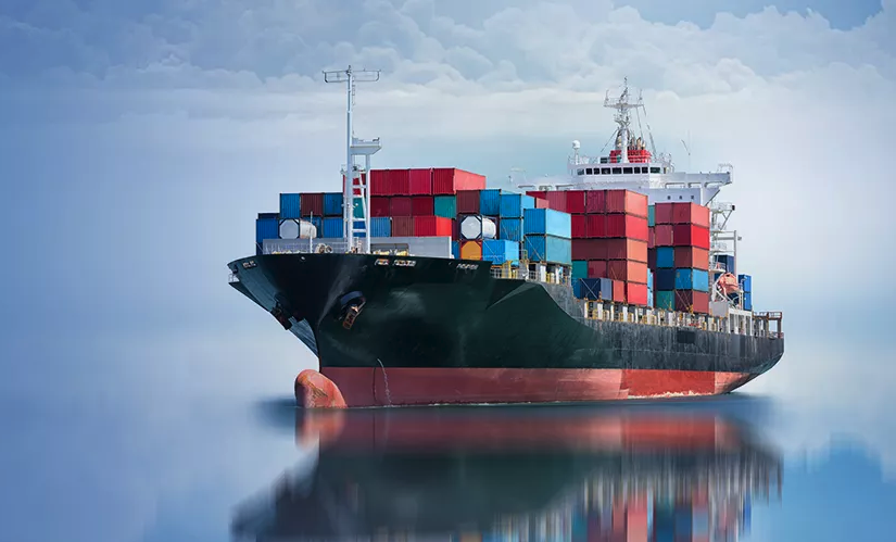 A cargo ship on still water with a cloudy blue sky